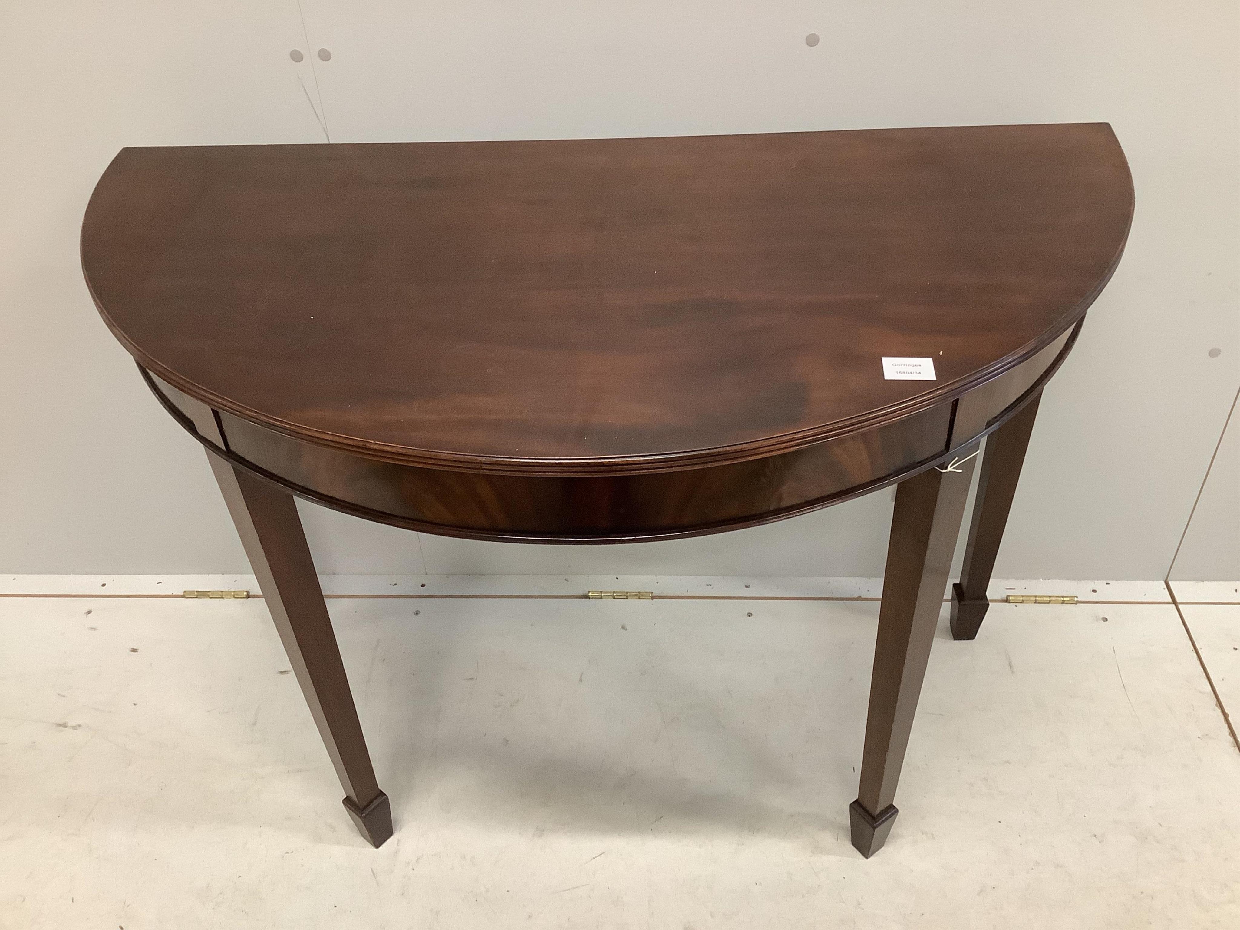 A George III style mahogany demi-lune console table on tapered legs and spade feet, width 114cm, depth 58cm, height 81cm. Condition - fair